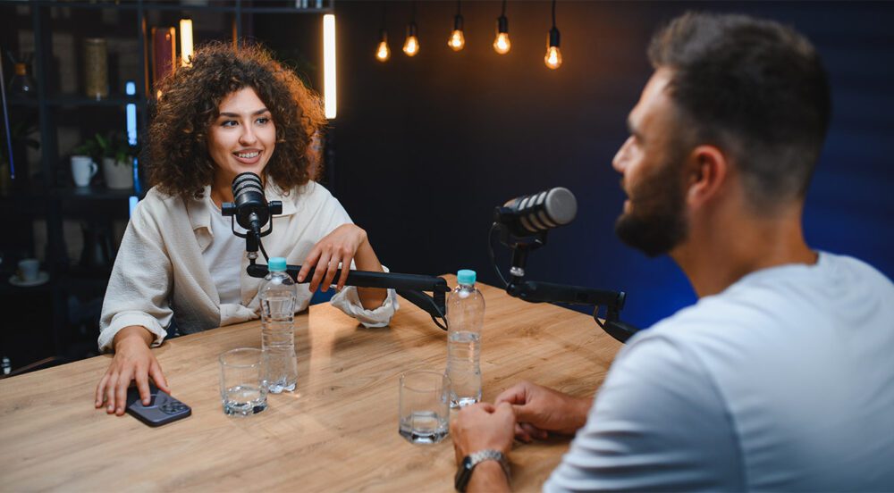 Content creator interviewing business executive for paid podcast in modern studio